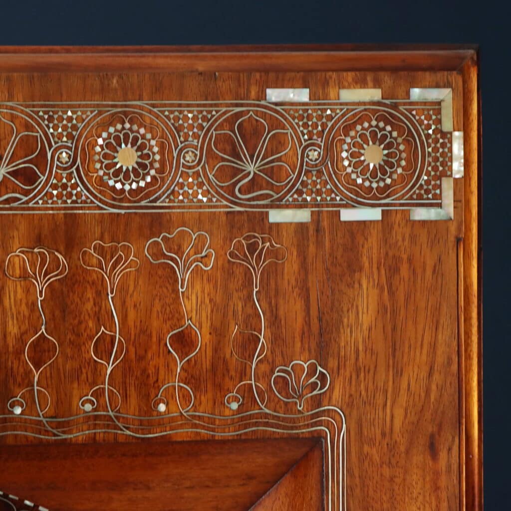 Detail of the wall mirror with Oriental-inspired decorative motifs and fine marquetry.