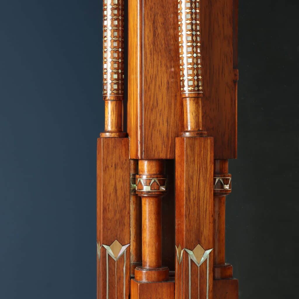 Detail of the wall mirror with Oriental-inspired decorative motifs and fine marquetry.