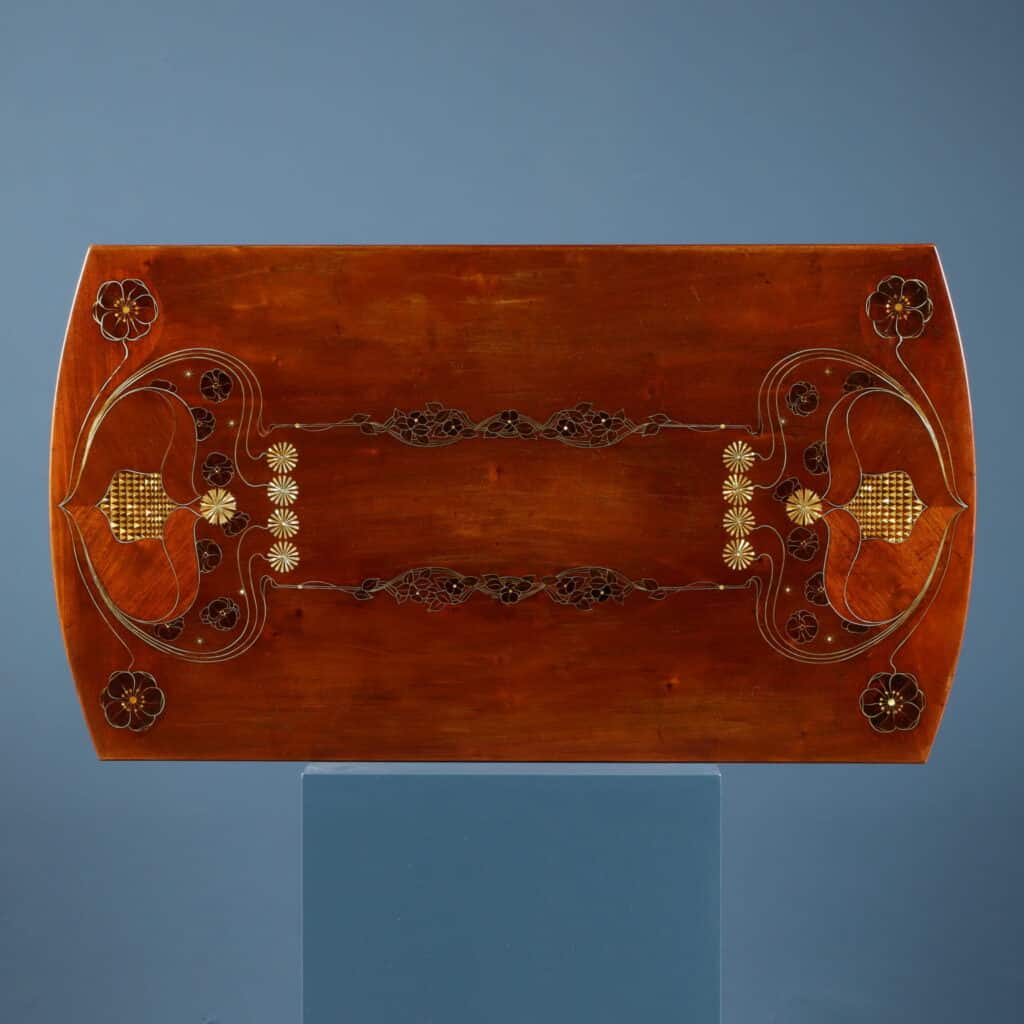 Mahogany writing desk enriched with brass stringing and floral marquetry.